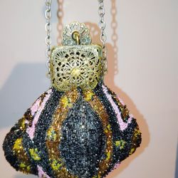 This vintage Art Deco beaded handbag/purse with a Bakelite/plastic frame and chain is a stylish accessory from the 1920s. The multi-color design and A
