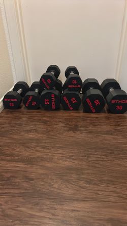 Ethos hard rubber dumbbells with steel handles. (1) pair of 10 lbs; (1) pair of 15 lbs (1) pair of 25 lbs; (1) pair of 30 lbs