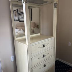 vintage-style lingerie chest features a cream finish, four drawers, and a lighted, mirrored upper hutch