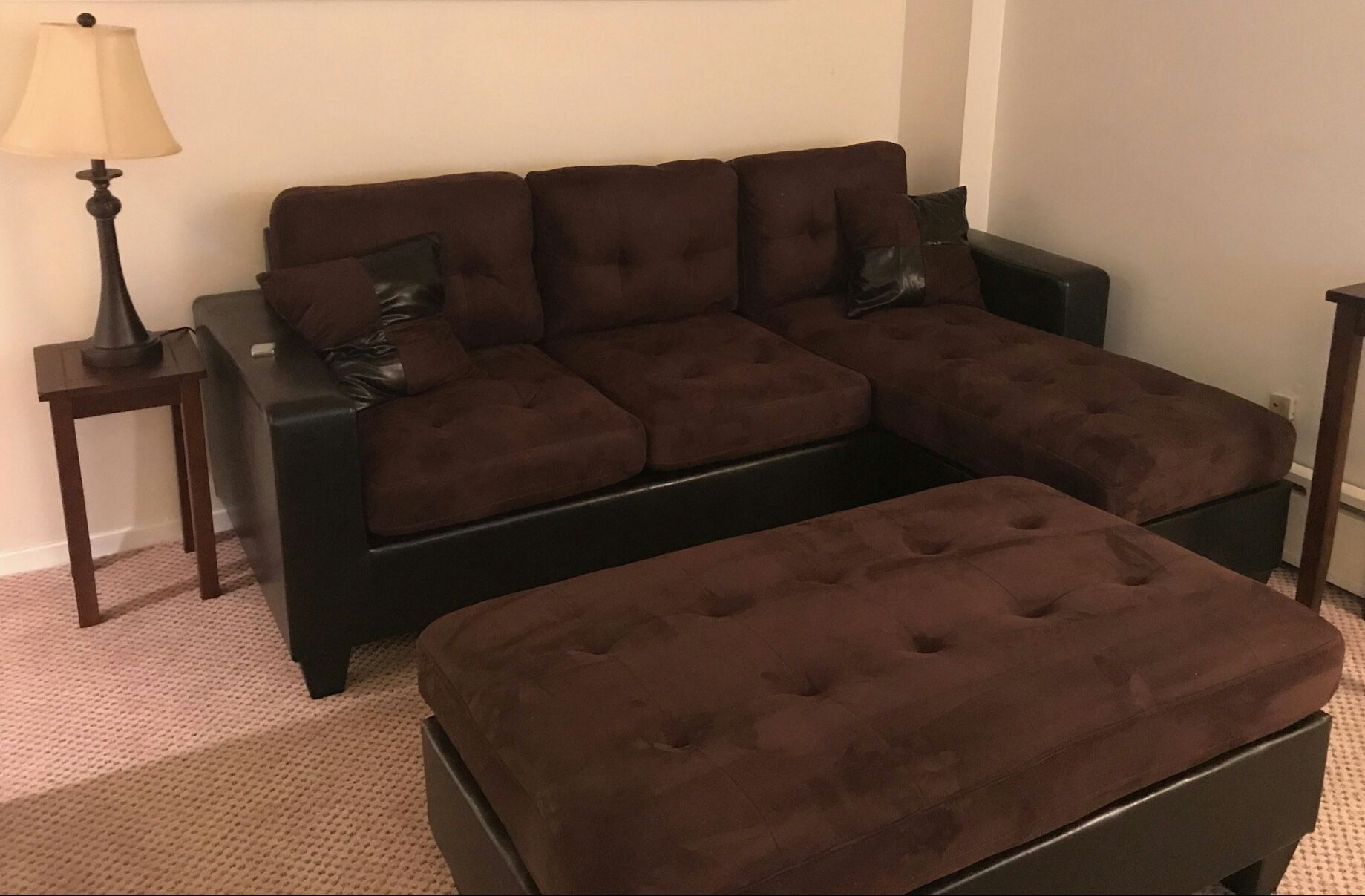 brown microfiber Sectional Sofa with Ottoman and 2 accent pillows.