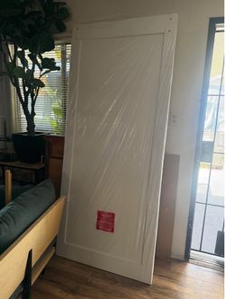white, single-panel Shaker-style sliding barn door.