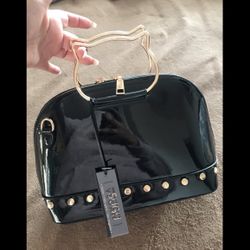 SUGU black satchel handbag featuring a distinctive gold-toned cat-shaped handle