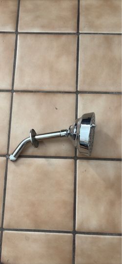 chrome-finish showerhead with an attached shower arm and wall flange