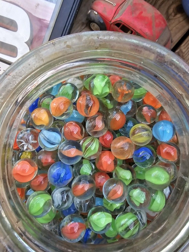 The product is a lot of 100 assorted colored glass marbles, including cat's eyes