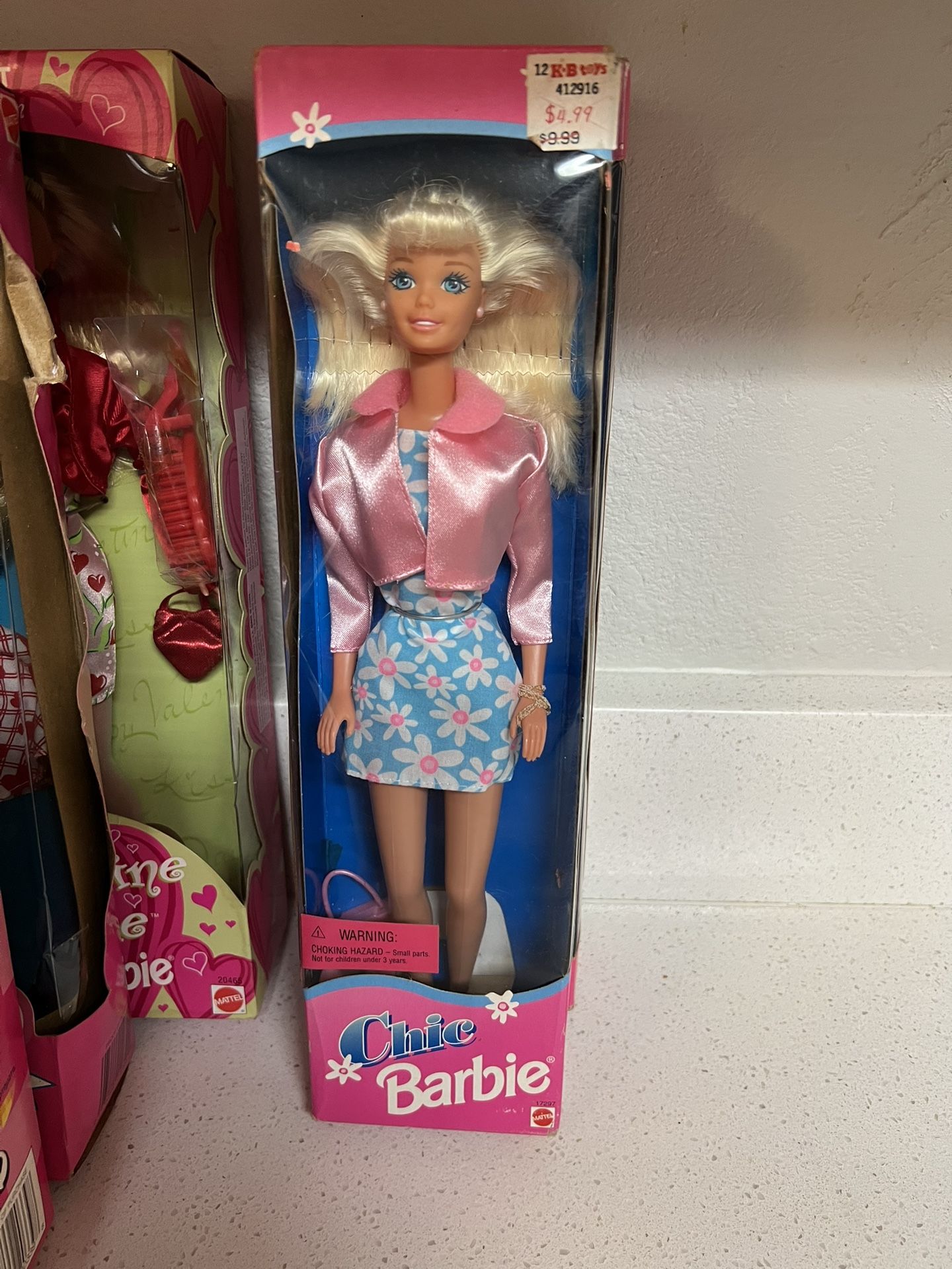 Chic Barbie doll, manufactured by Mattel in 1996. The doll wears a blue dress with a daisy flower print and a pink jacket. It is part of the Fashion