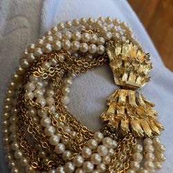 Vintage multi-strand pearl bracelet with a gold-tone floral clasp.
