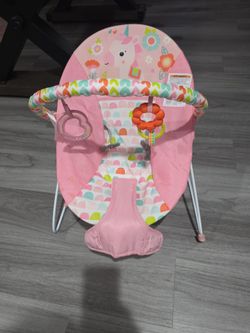 Bright start pink baby bouncer and white and black donut nursing pillow baby support.