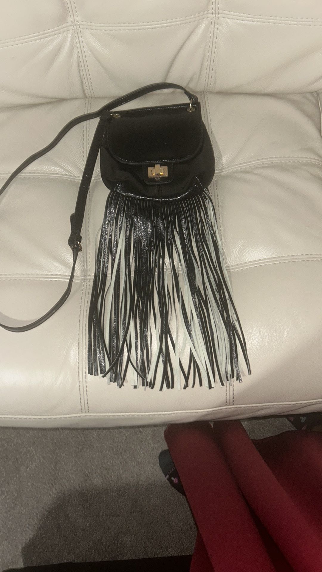 Stylish black crossbody bag with fringe detailing. Perfect for adding a chic touch to any outfit.