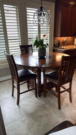Beautiful high top dining/Breakfast nook table with 4 sturdy chairs in immaculate condition.