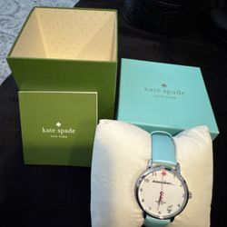 Kate Spade watch, featuring the light blue strap and “somewhere…” cocktail-themed face