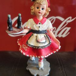 The Coca Cola Carhop "Doll Face" 1999 Madam Alexander-E 1/2856 is a collectible decorative item made of resin with a colorful Americana style design. 