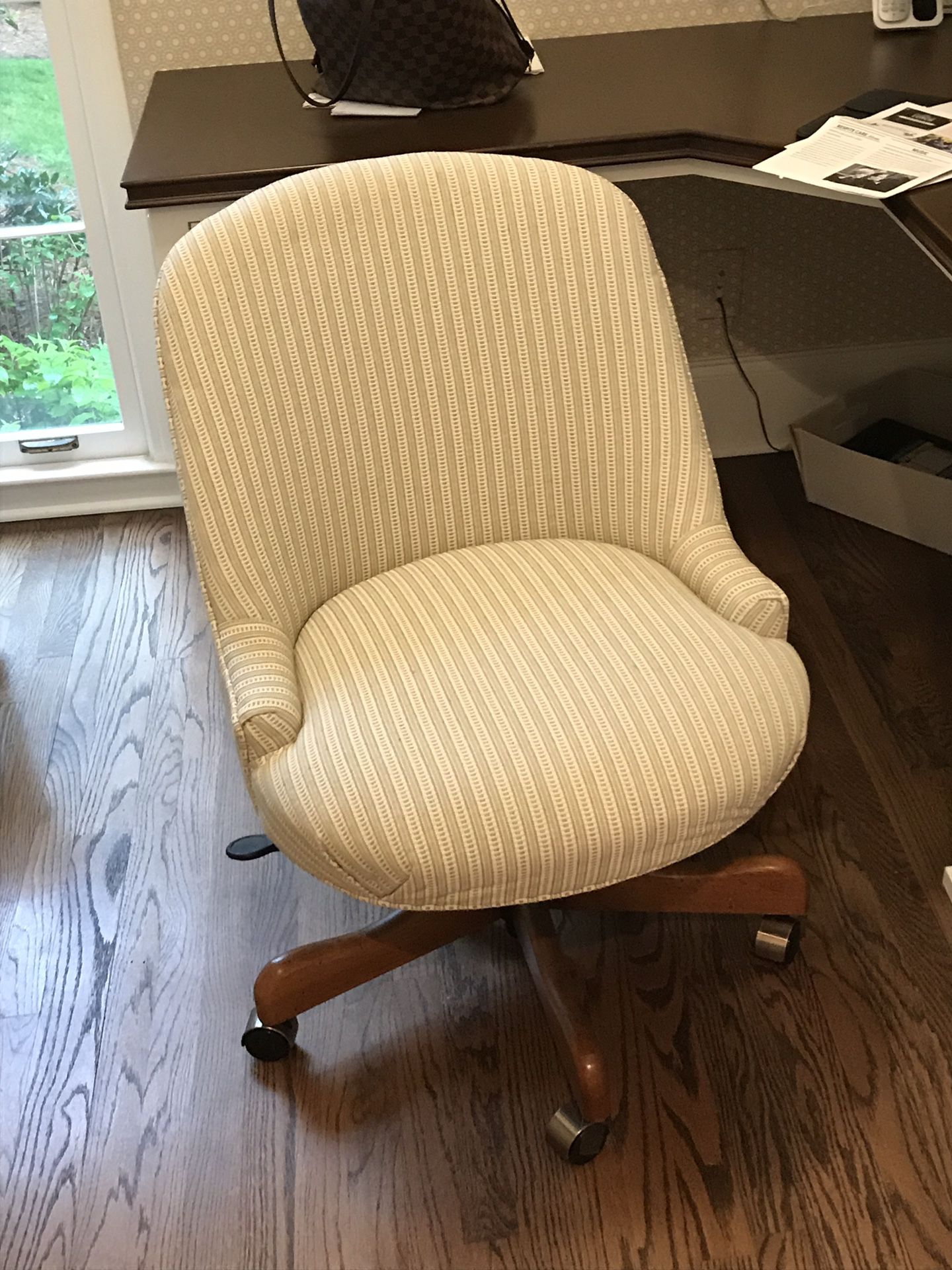 Upholstered desk chair on wood base with wheels