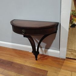 mid-century traditional demilune (half-round) wall-mounted console table manufactured by the prestigious Hekman Furniture Co.