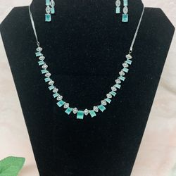 rhodium-plated American diamond necklace and earring set studded with green cubic zirconia stones. 
