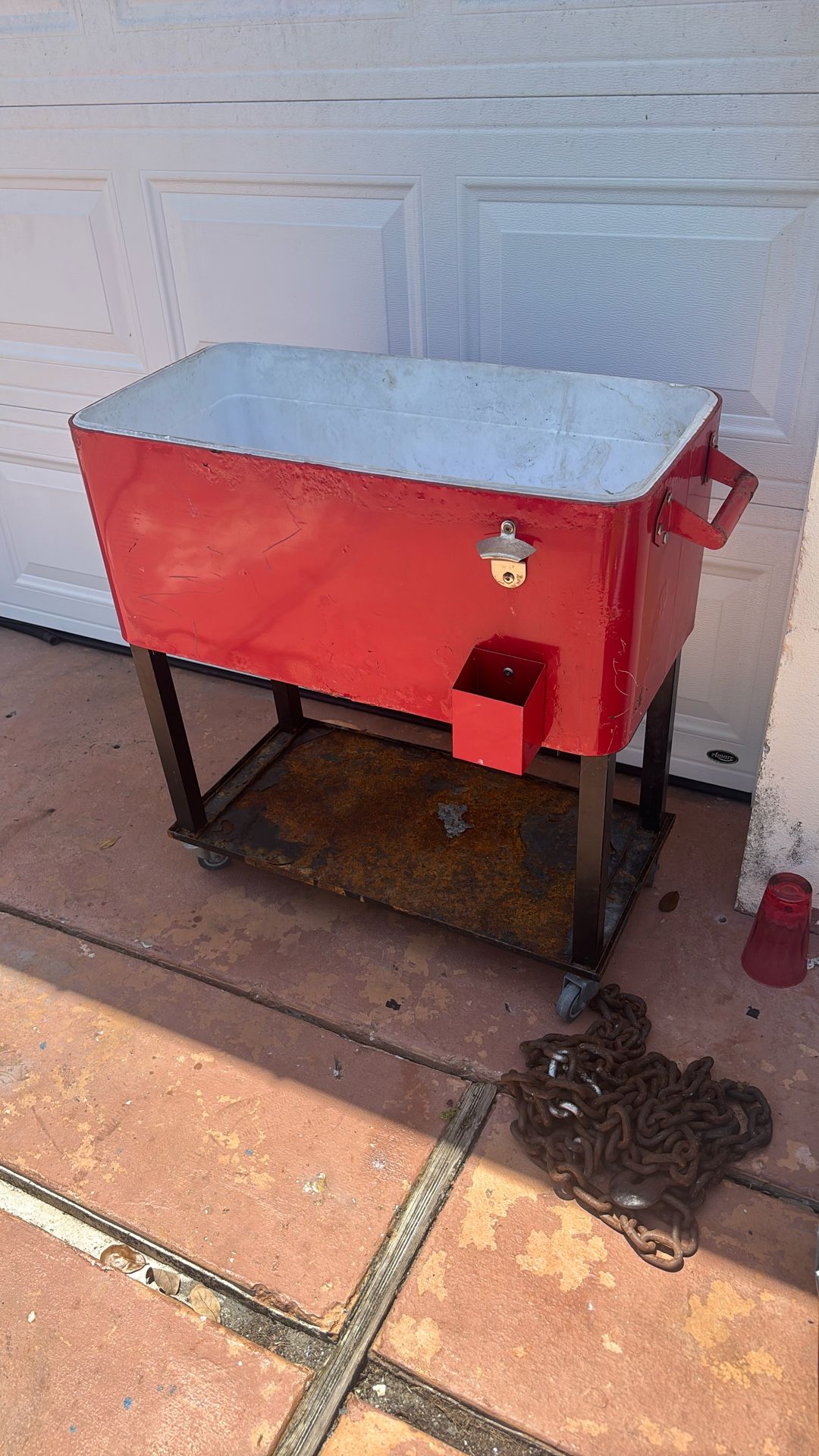 Cooler on a cart with bottle, cap opener, and drain hole