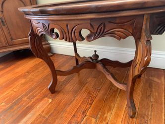 Antique carved walnut oval occasional table with relief top.
