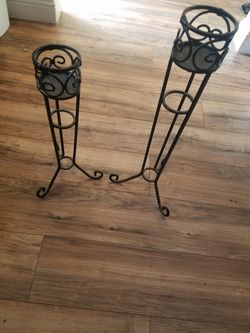 Black wrought iron 4' candle holders one is 20 inches high other is 25 inches high