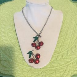 Two charming vintage enamel metal red cherry pieces one is a necklace and one is a Charm they are both signed JJ