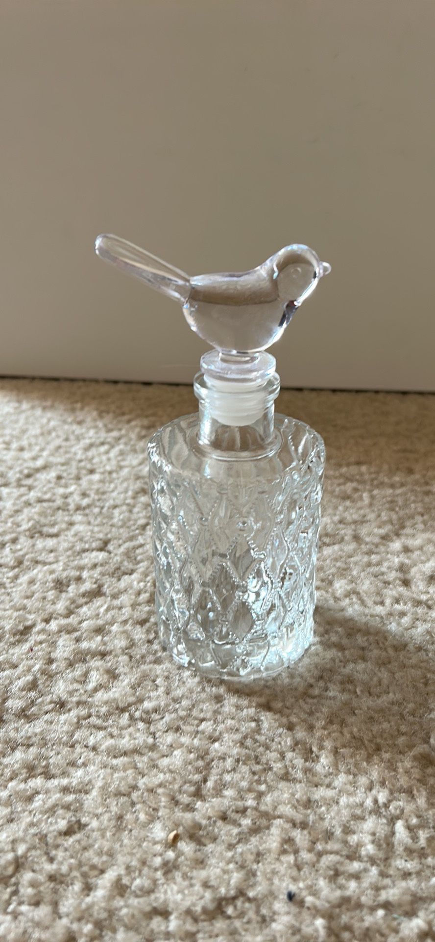 Beautiful glass perfume bottle with bird on top