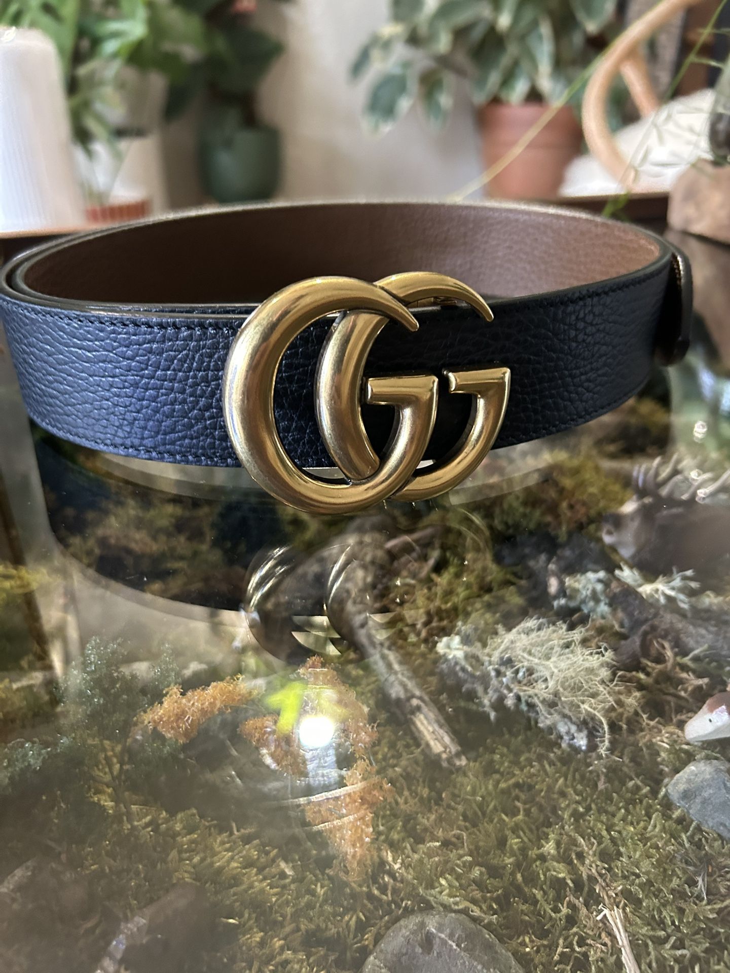 Gucci GG Marmont belt, characterized by its distinctive gold-toned Double G buckle and black leather strap