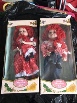Raggedy Ann and Raggedy Andy. Each holding doll. New in boxes.