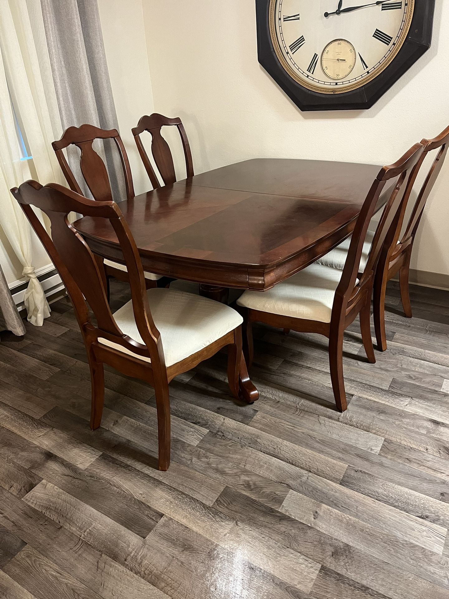 A dining room set made of solid wood. A large table, 6 chairs, a sideboard, and a chest of drawers.