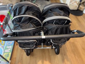 Double stroller with tire pump attachment under seat