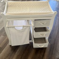 Baby changing table with hamper and three drawers.   $50 OBO