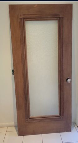 wooden interior door with a frosted or textured glass panel