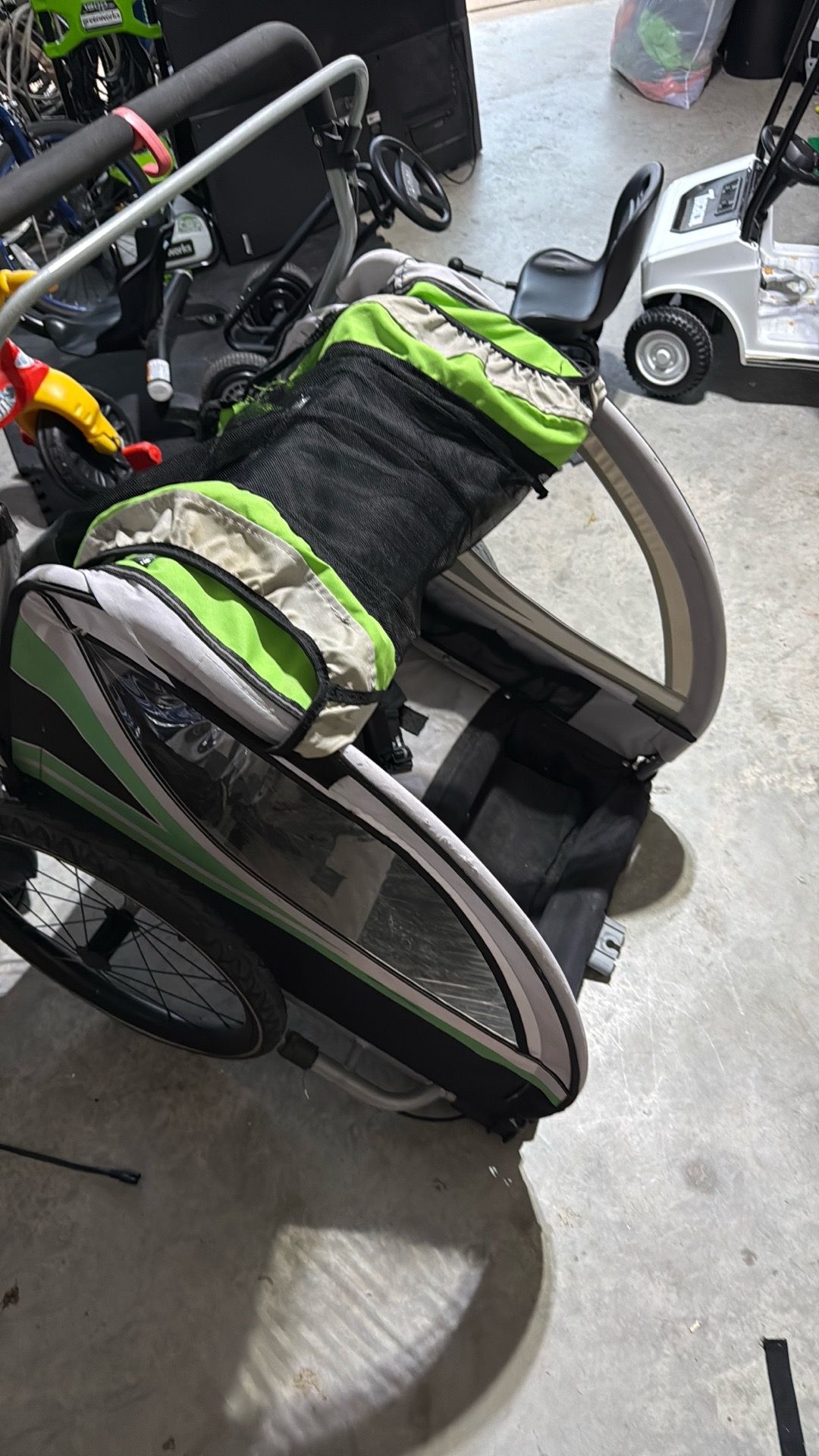 Yes — that appears to be an Aosom child bike trailer/stroller. The green, gray, and black color scheme plus the window shape match a lot of the older