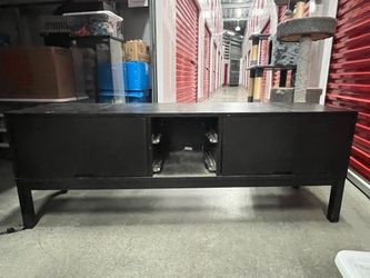 Small wooden entertainment center with pullout doors for storage