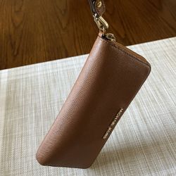 It’s A Michael Kors wristlet wallet the color is brown it is barely used