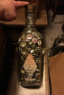 1 Vintage Vodka Bottle with Swinging Stand and Bottle caps.