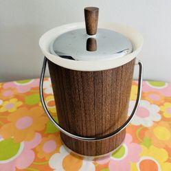 Vintage Kromex ice bucket Faux wood vinyl exterior. Stainless lid , handle and bottom. Knob on lid is wood. Inside plastic insert is clean , no holes.
