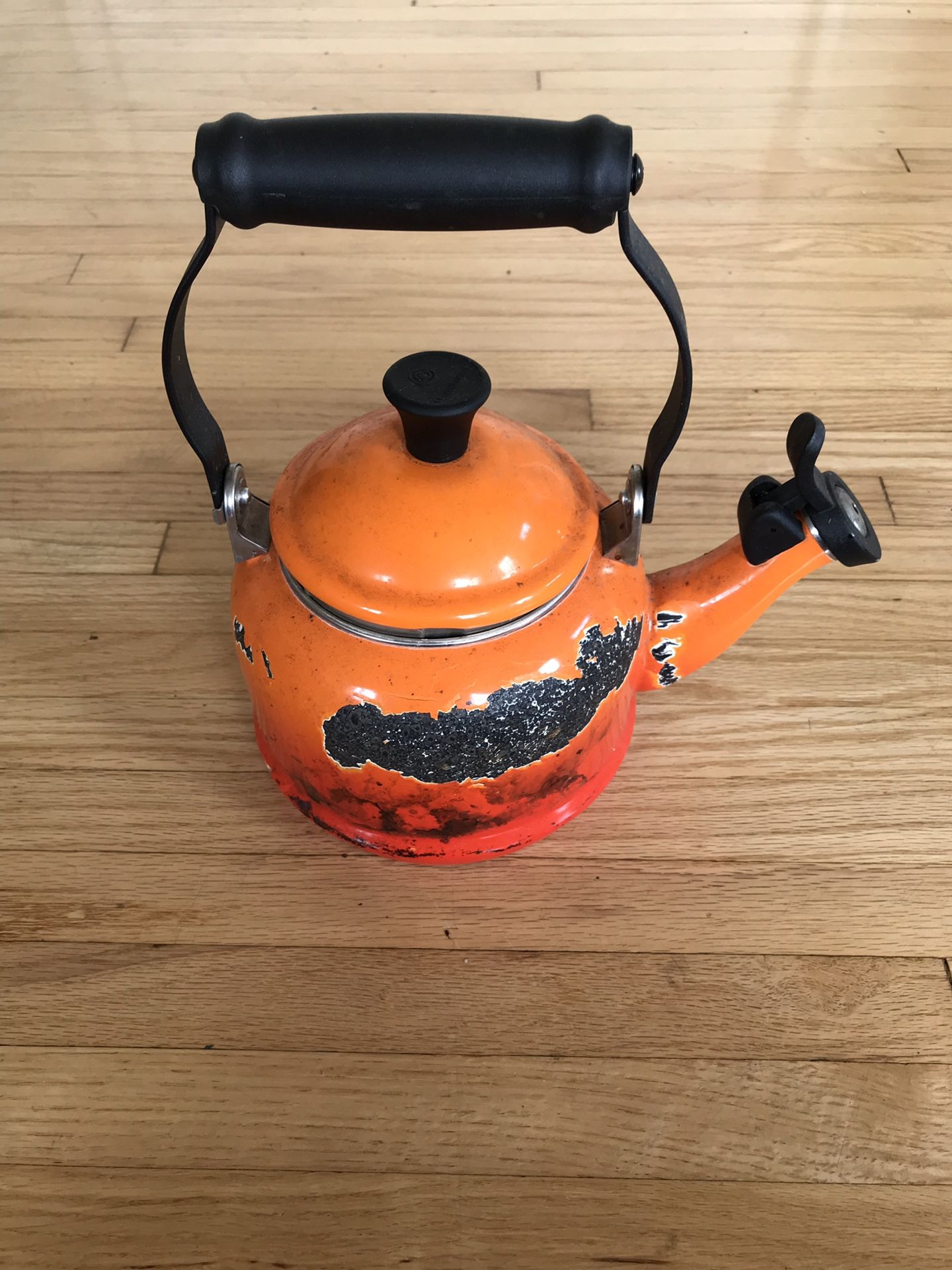 Le Creuset orange tea pot with some enamel cracked off