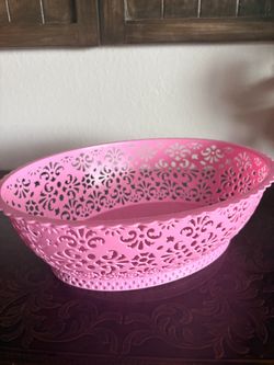 Oval pink plastic basket with an intricate floral and lace-like cutout pattern