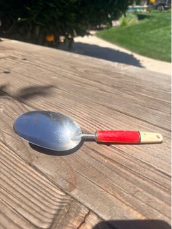 Vintage dry scoop with red handle.