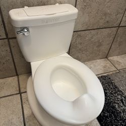 toddler potty training toilet. Makes a flushing sound and has a small storage compartment.