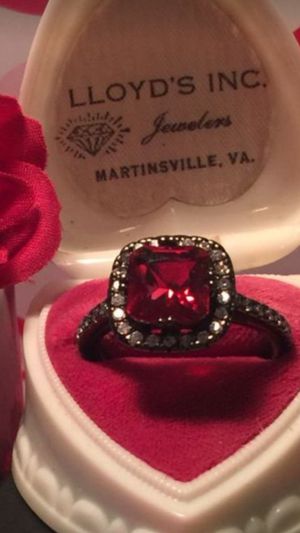Photo Halo shaped ruby on 18 kt black gold band with white sapphires size7