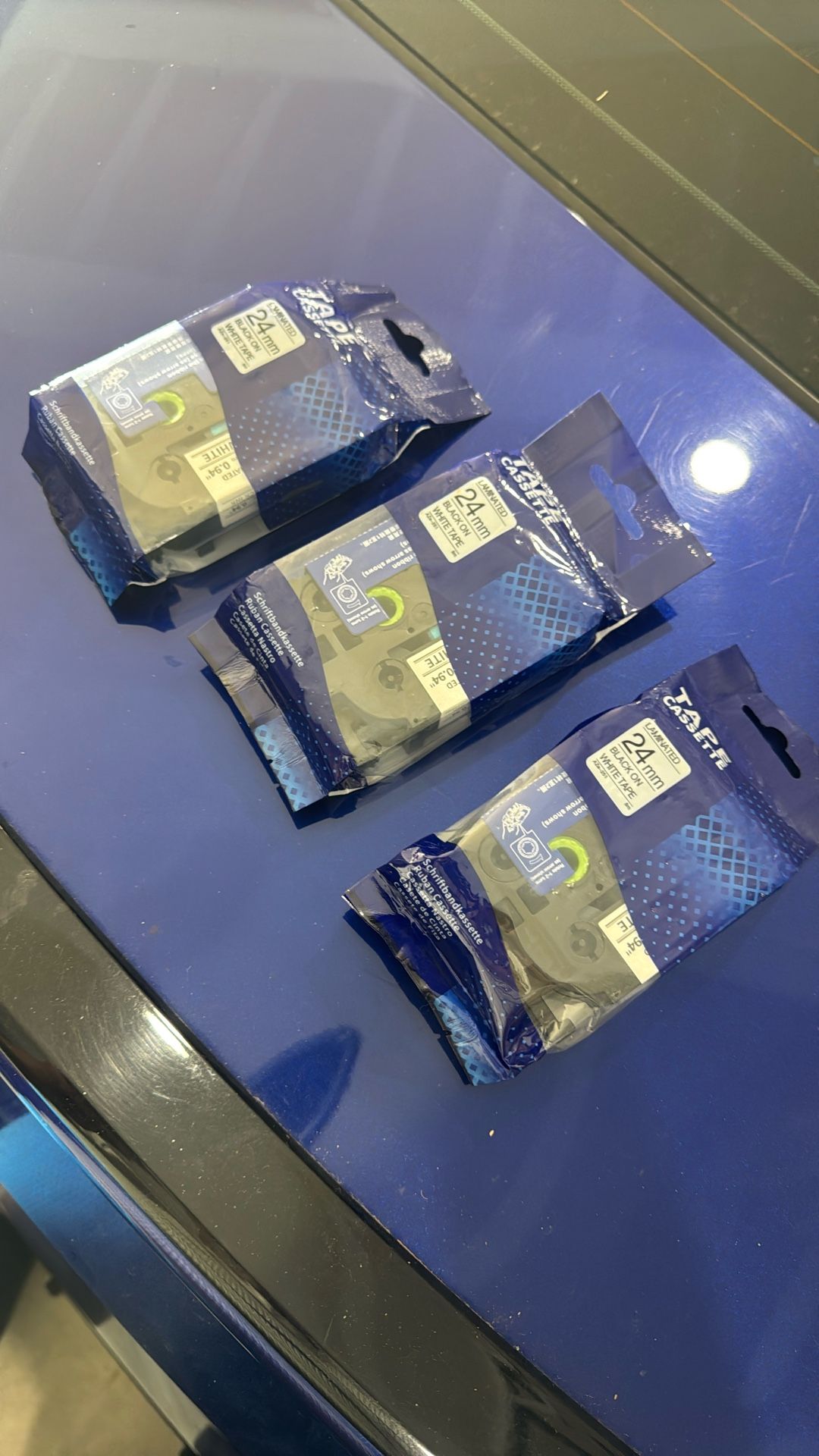 replacement label tape cassette for Brother P-Touch label printers, specifically a 24mm black-on-white laminated tape