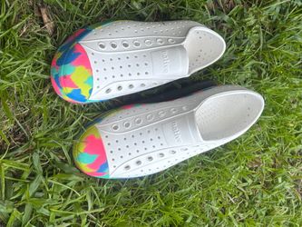 Lightweight Native Jefferson slip-on shoes are size M7/W9. These white EVA shoes have a multi-color tie-dye pattern on the toe and sole. The uppers ha