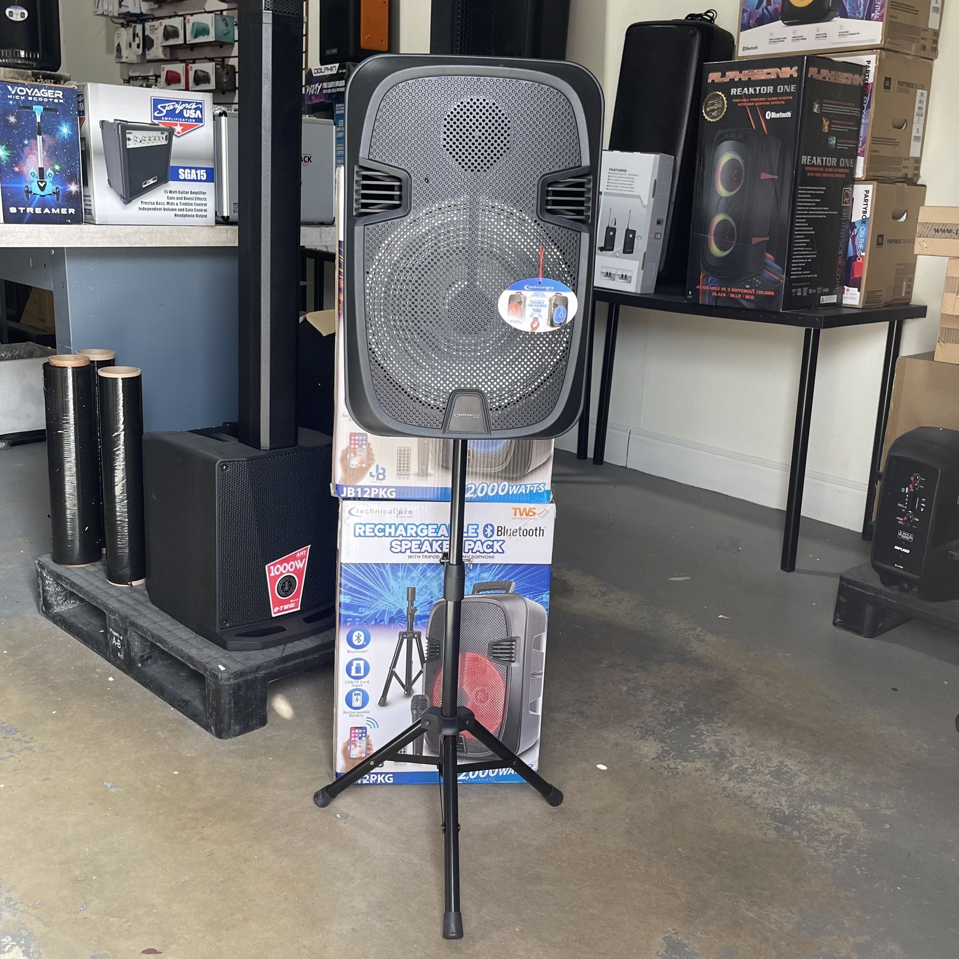 Rechargeable speaker with tripod and microphone included. Bluetooth. USB, FM radio, rechargeable battery, and LED lights. 12” woofer.