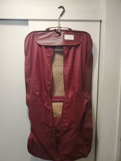 vintage burgundy red Samsonite folding travel garment bag with a textured finish, dual handles, and a shoulder strap.