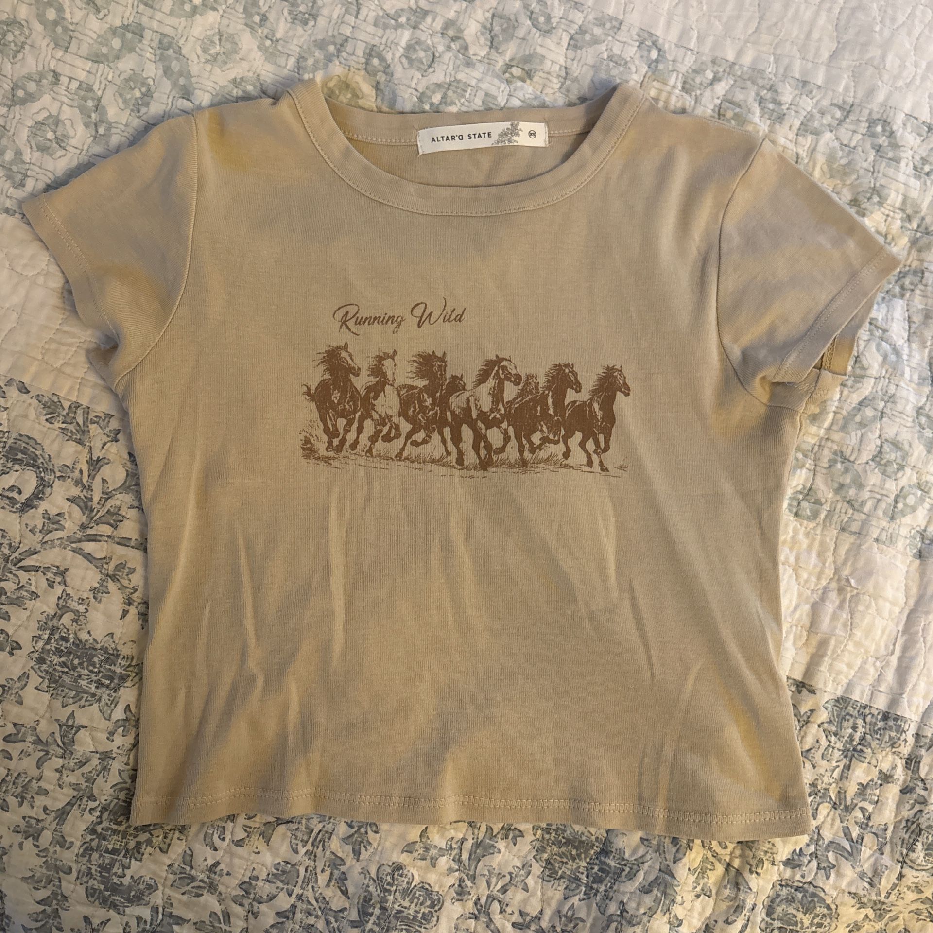 Tan and brown Altar’d State baby tee, horse design and says “Running Wild”
