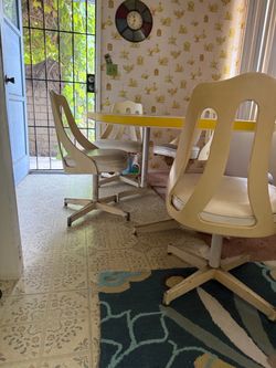 1970s table with white vinyl swivel chairs