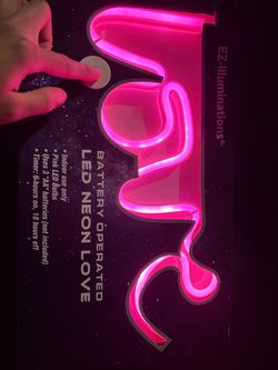 Pink neon sign shaped like the word 'love'