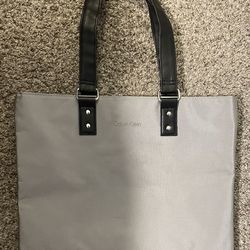 Calvin Klein Tote Bag -New. Light Shimmery Gray Base Color, With Black Handles And Black Bottom. 12 Inches Tall  Plus Straps, 15 Inches Wide