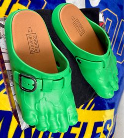 These are Bravest Studios Green Hulk Foot Clogs, featuring a molded green design with an adjustable metal buckle.