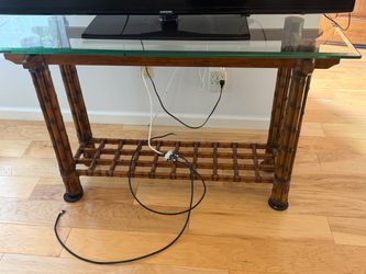 Tv stand or console stand. Glass top, bamboo legs.