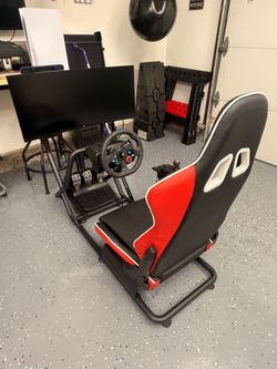 PS5 with controller, Logitech G29 Racing Sim with shifter, adjustable cockpit seat, and LG curved monitor